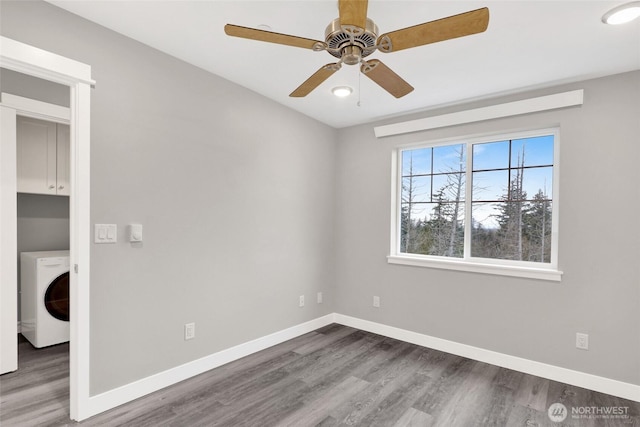 unfurnished room with washer / clothes dryer, baseboards, and wood finished floors