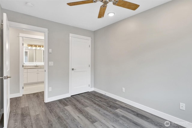 unfurnished bedroom featuring dark wood-style floors, baseboards, and ceiling fan