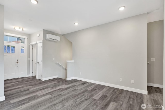 foyer with recessed lighting, baseboards, wood finished floors, and a wall unit AC