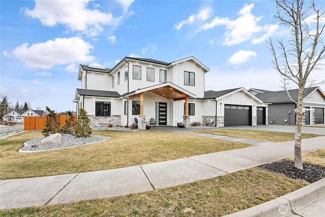 modern farmhouse with solar panels, fence, a front yard, stone siding, and an attached garage