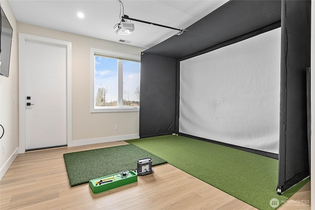 game room with recessed lighting, baseboards, golf simulator, and wood finished floors