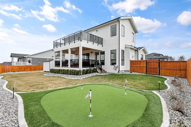 back of property with a patio area, a balcony, a lawn, and a fenced backyard