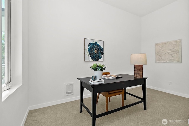 home office featuring baseboards, visible vents, and light carpet