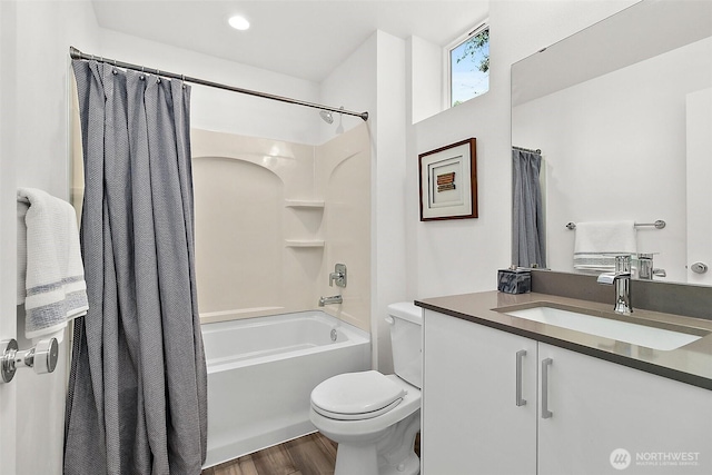 bathroom featuring wood finished floors, toilet, vanity, and shower / bath combo