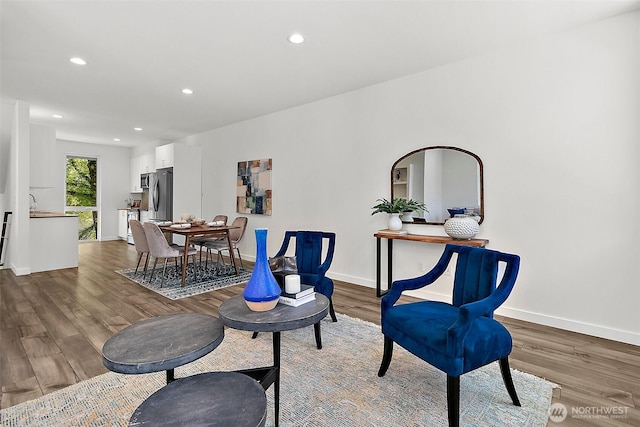 living area with recessed lighting, baseboards, and wood finished floors