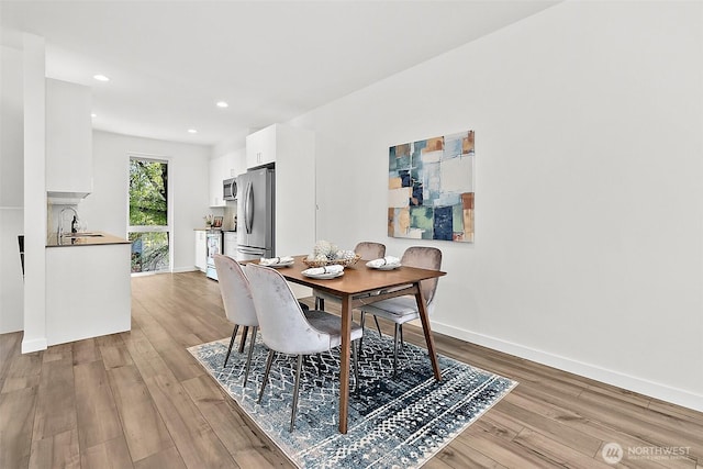 dining area with recessed lighting, light wood-type flooring, and baseboards