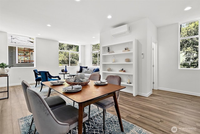 dining area featuring light wood finished floors, recessed lighting, a wall mounted AC, and baseboards