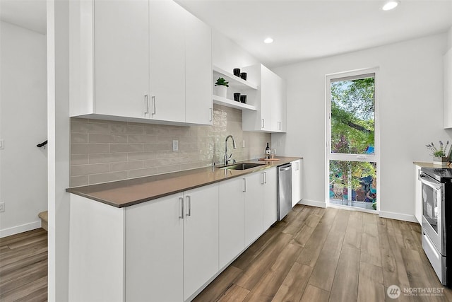 kitchen with open shelves, dark wood-style flooring, stainless steel appliances, a sink, and backsplash