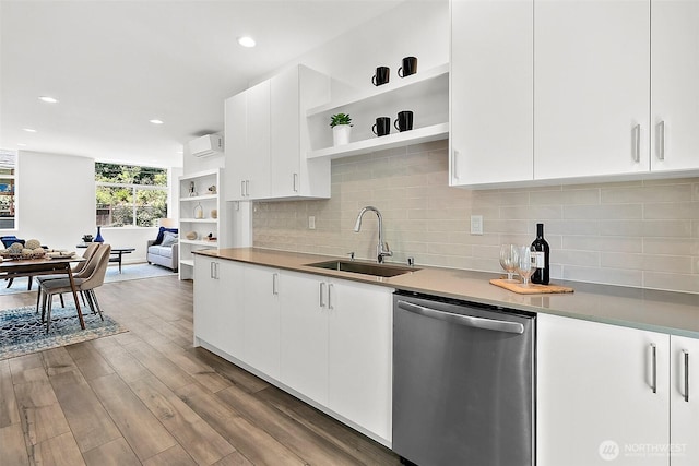 kitchen with wood finished floors, open shelves, a sink, decorative backsplash, and stainless steel dishwasher