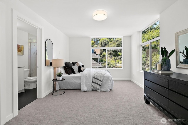 bedroom with ensuite bath, carpet, and baseboards