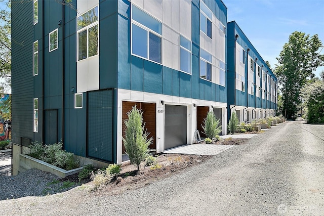 view of building exterior with driveway and an attached garage