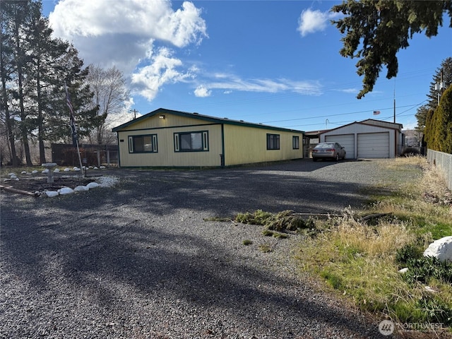 exterior space with a garage, an outdoor structure, and fence