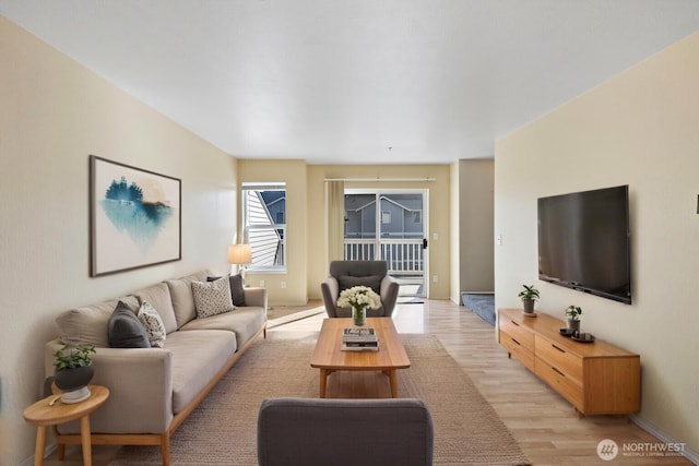 living room with baseboards and light wood finished floors