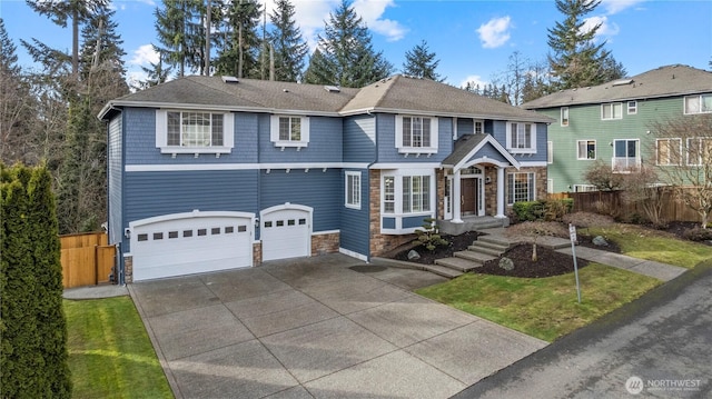 view of front facade with stone siding, driveway, a garage, and fence