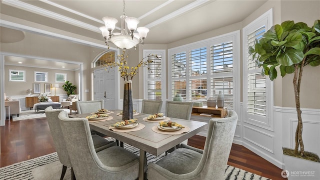 dining space with a wainscoted wall, an inviting chandelier, wood finished floors, and a decorative wall