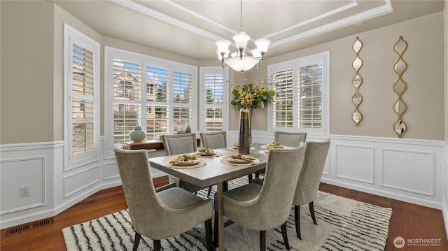 dining area with visible vents, an inviting chandelier, dark wood-type flooring, and a tray ceiling