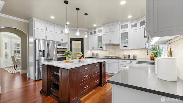 kitchen with white cabinetry, decorative backsplash, appliances with stainless steel finishes, and a sink