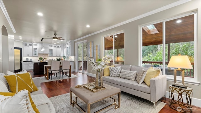 living room with a ceiling fan, wood finished floors, baseboards, recessed lighting, and ornamental molding