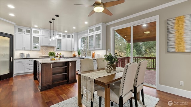 dining room with baseboards, recessed lighting, ornamental molding, ceiling fan, and dark wood-type flooring