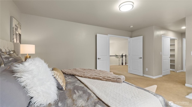 bedroom with baseboards, a closet, and light carpet