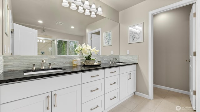 full bath featuring tasteful backsplash, visible vents, walk in shower, and a sink