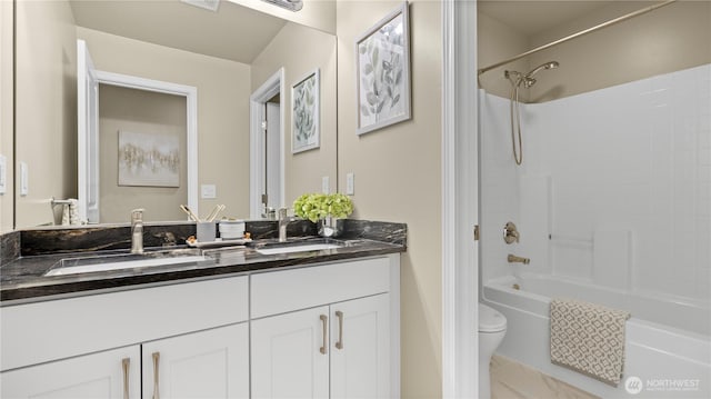 full bathroom with a sink, toilet, double vanity, and shower / tub combination