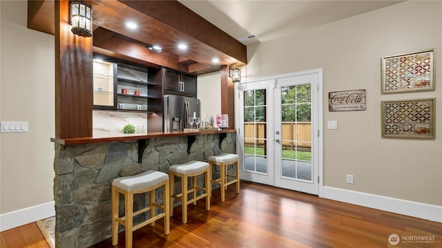 bar with wood finished floors, visible vents, baseboards, french doors, and stainless steel refrigerator with ice dispenser