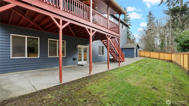 view of yard with stairway, a storage shed, a fenced backyard, an outdoor structure, and a patio area