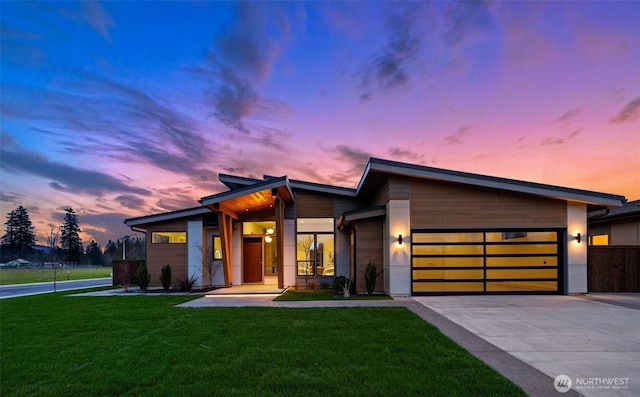 contemporary home with driveway, a front yard, and a garage