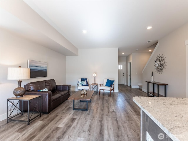 living room featuring recessed lighting, baseboards, and wood finished floors