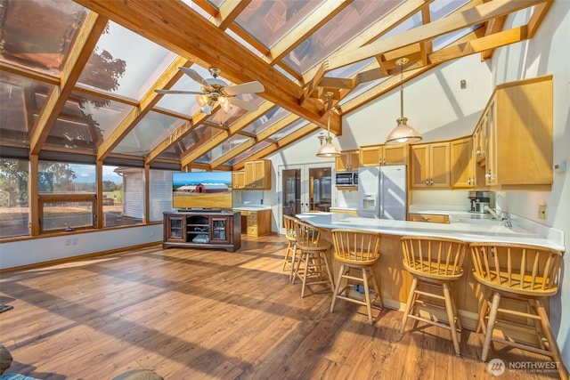 4596 Woodcock Rd, Sequim, WA 98382 - kitchen with light countertops, a peninsula, hardwood / wood-style flooring, stainless steel microwave, and refrigerator with ice dispenser