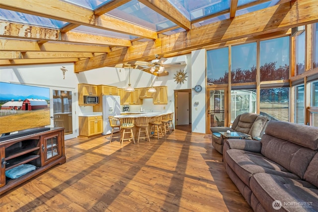 4596 Woodcock Rd, Sequim, WA 98382 - living area featuring wood finished floors, a healthy amount of sunlight, ceiling fan, and lofted ceiling with skylight
