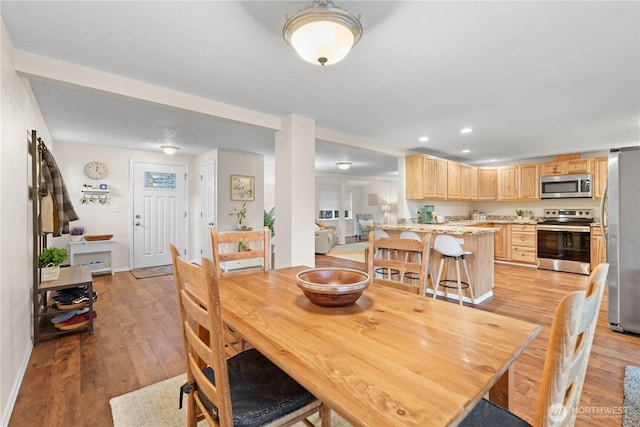 dining area featuring recessed lighting, baseboards, and light wood finished floors