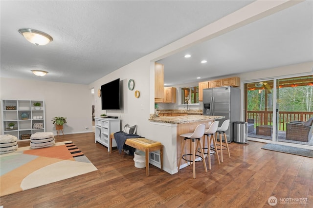 living room featuring wood finished floors, visible vents, baseboards, recessed lighting, and a textured ceiling