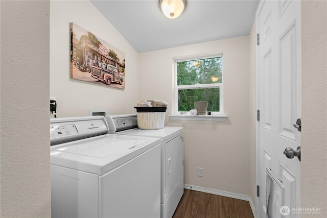 washroom featuring baseboards, dark wood-type flooring, washing machine and dryer, and laundry area