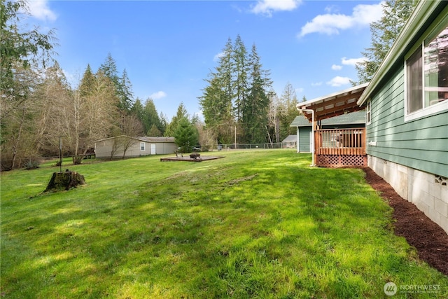 view of yard with a wooden deck and fence