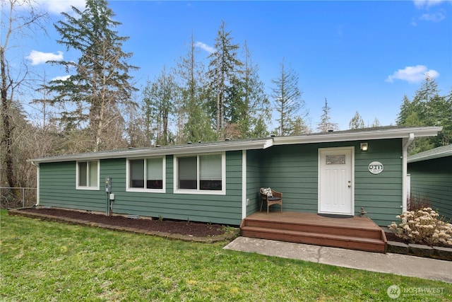 view of front of house with a deck and a front yard