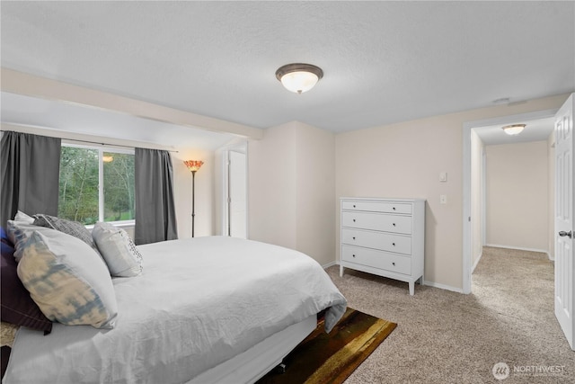 carpeted bedroom featuring baseboards and a textured ceiling