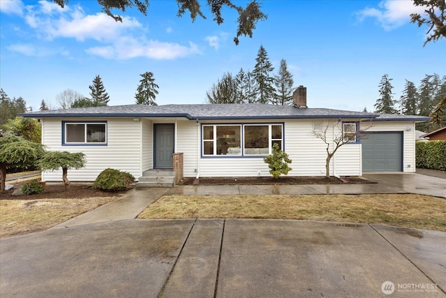 ranch-style house with a garage, a chimney, and driveway