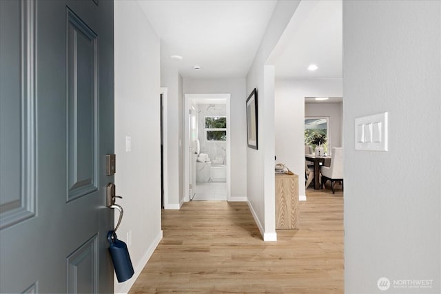 foyer entrance with light wood-style flooring and baseboards