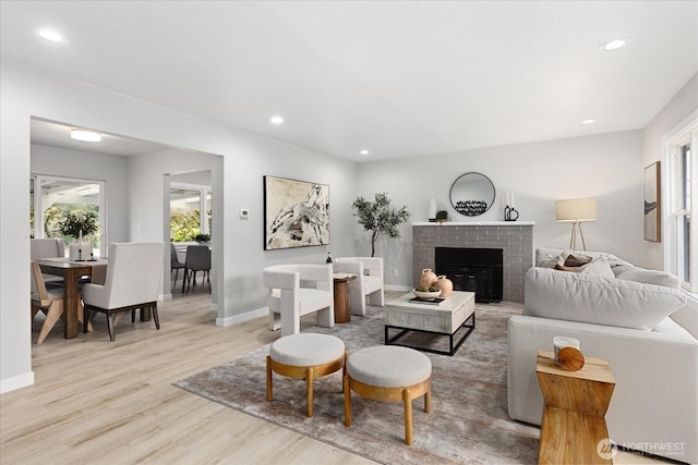 living room featuring recessed lighting, a fireplace, baseboards, and wood finished floors