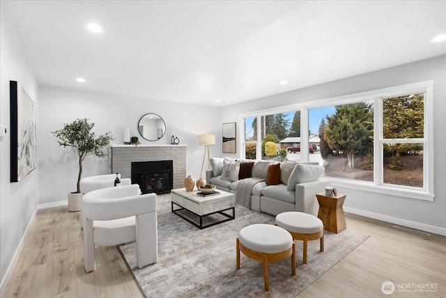 living area with recessed lighting, baseboards, and light wood-type flooring