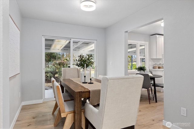 dining area with baseboards and light wood-style floors