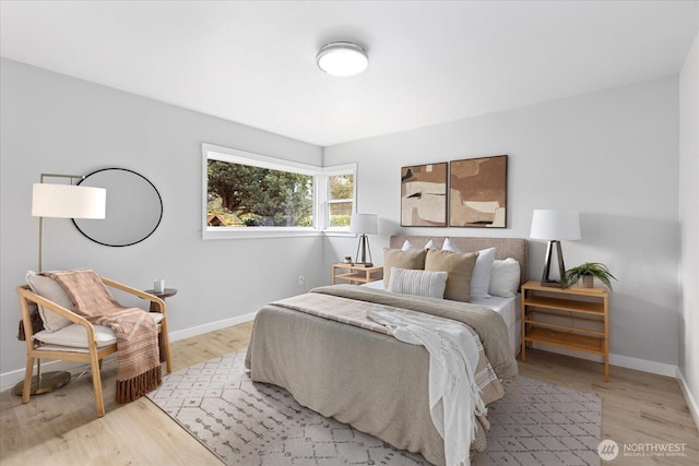 bedroom with light wood-type flooring and baseboards