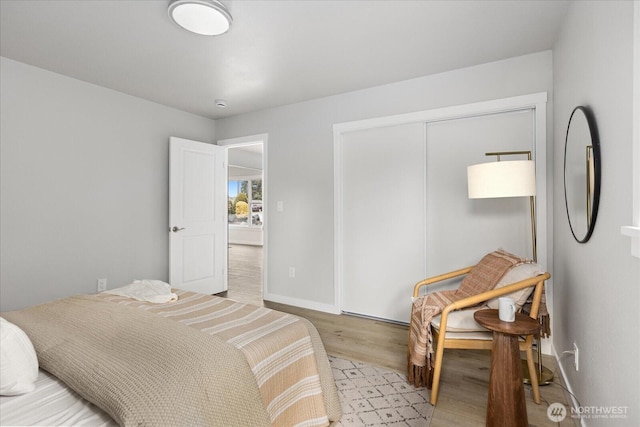 bedroom with a closet, baseboards, and wood finished floors