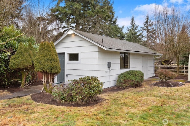 view of side of home with a lawn and a shingled roof