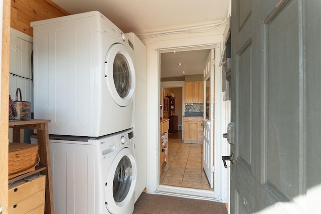 washroom with estacked washer and dryer and light tile patterned floors
