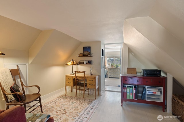 office area featuring vaulted ceiling, wood finished floors, and baseboards
