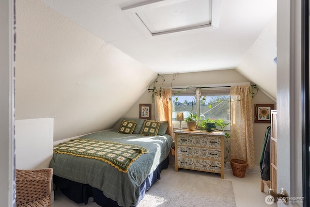 bedroom featuring vaulted ceiling, attic access, and carpet flooring