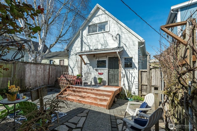 rear view of property with fence and a patio